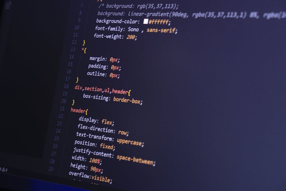 A photograph displaying a close-up view of a computer screen with lines of colorful HTML and CSS code, including properties like background-color, margin, padding, and border. The code is written in v